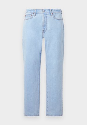 Jean en denim bleu clair avec une coupe droite, cinq poches, fermeture à bouton et texture légèrement délavée. Coutures visibles aux coutures.