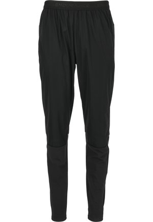Sorte træningsbukser i let materiale, med elastisk talje og tapered fit med knædetaljer for ekstra design. 
