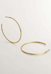 Pendientes de aro de oro con un diseño elegante, forma redonda, textura suave y cierre minimalista de extremo abierto.