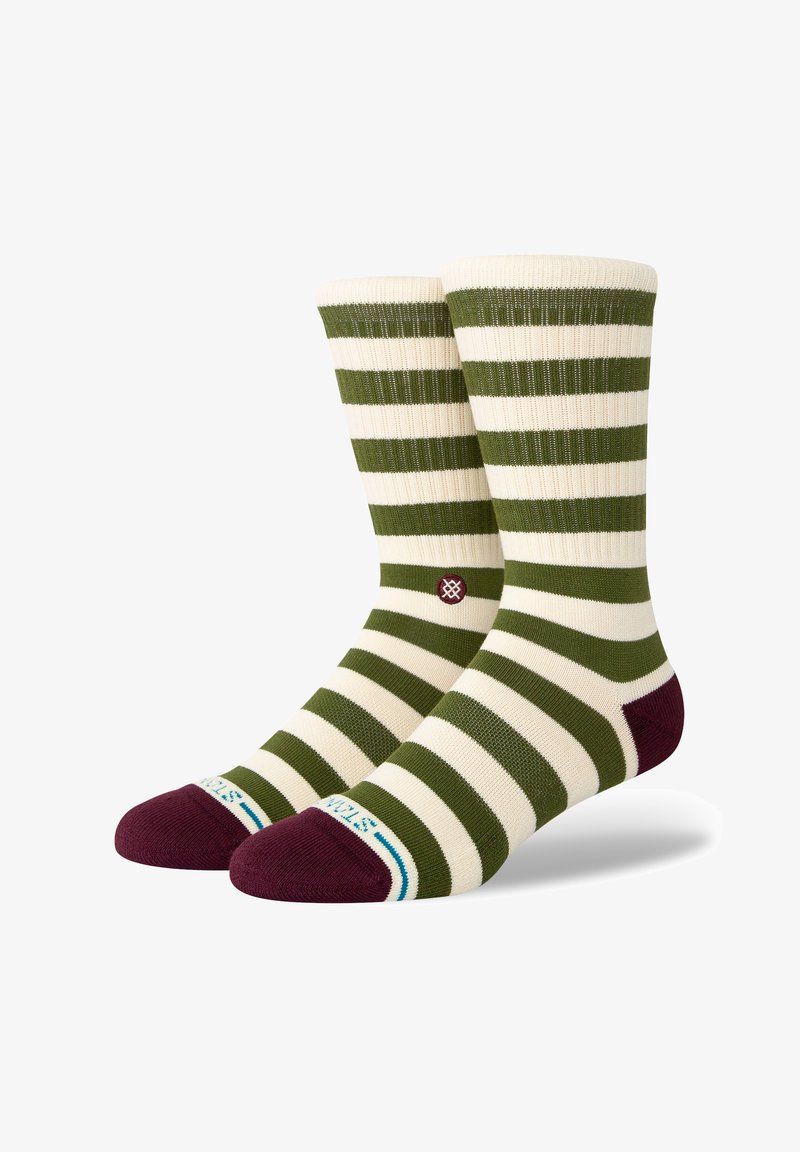 Meias listradas com riscas alternadas em verde-oliva e creme, apresentando destaques em marrom na ponta e um pequeno detalhe do logotipo.