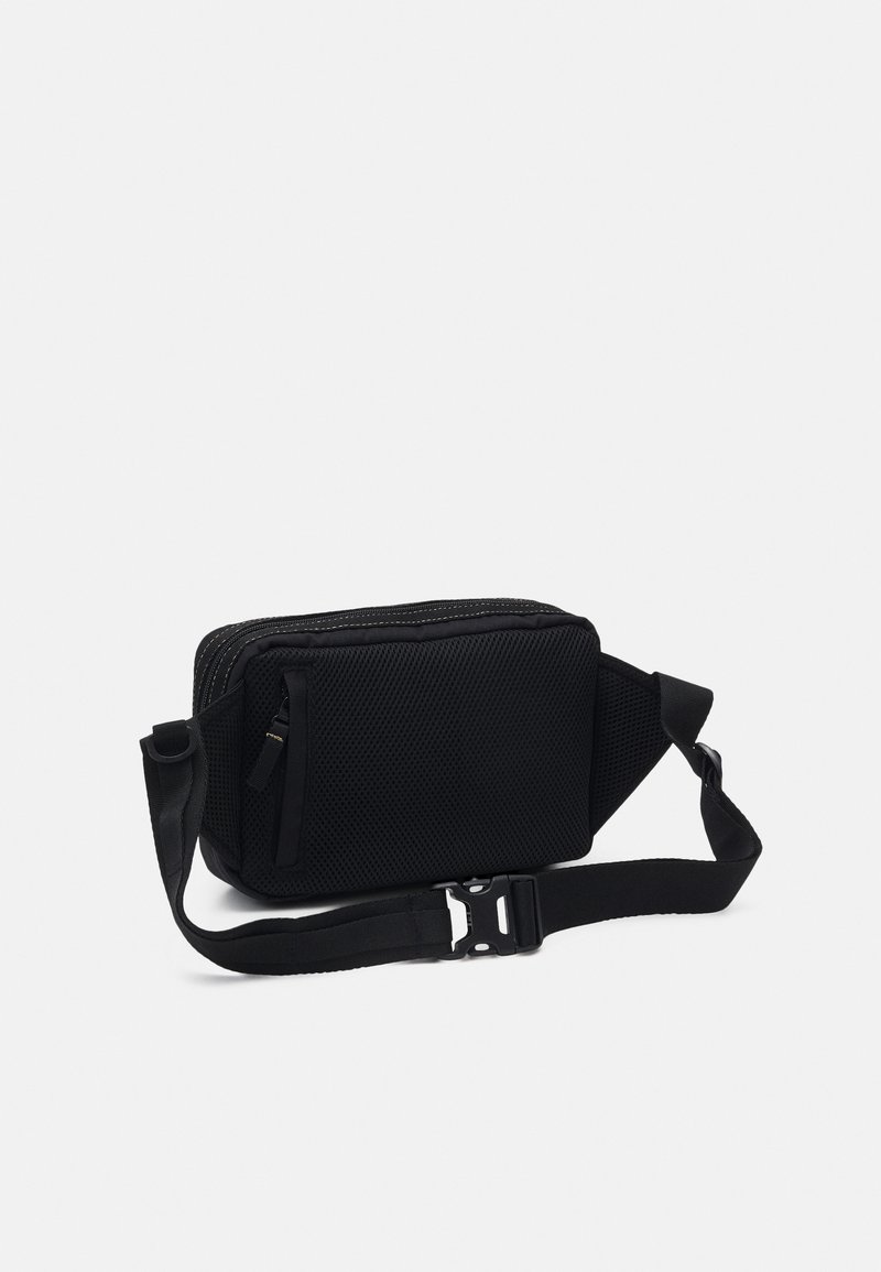 Borsa a tracolla nera in tessuto a rete testurizzato, con chiusura a zip, tracolla regolabile e una piccola tasca frontale per ulteriore spazio di archiviazione.