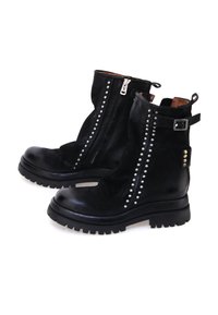 Crne čizme do članaka imaju teksturiranu kožnu gornjište, srebrne zakovice duž ivica zatvarača i čvrst gumeni đon za prianjanje.