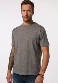 Grijs kortemouwen t-shirt met een subtiel textuurpatroon, ronde halslijn en een rechte zoom. Draagt het met een donkere spijkerbroek en zichtbare tatoeages.