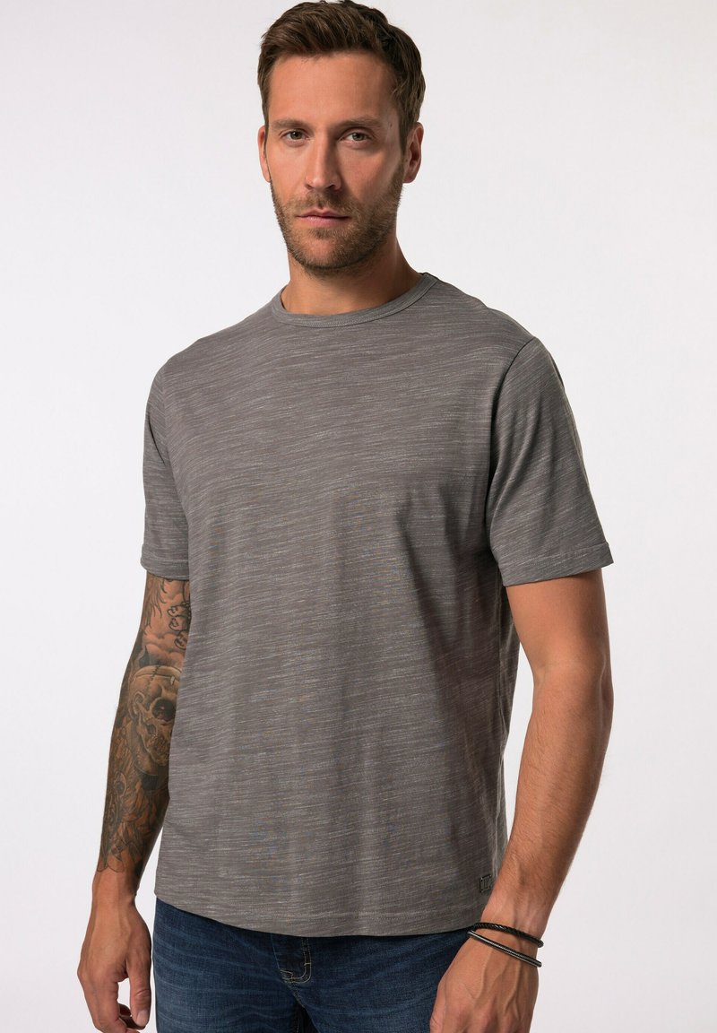 Grijs kortemouwen t-shirt met een subtiel textuurpatroon, ronde halslijn en een rechte zoom. Draagt het met een donkere spijkerbroek en zichtbare tatoeages.