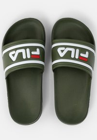 Gröna gummisandaler i slides-modell med vit och röd Fila-logotyp på remmarna, med en strukturerad yta och platt design för komfort.
