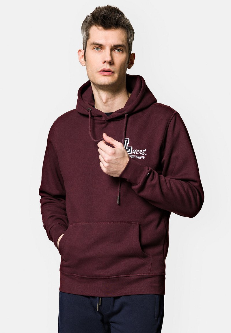 Bordowy hoodie wykonany z miękkiej mieszanki bawełny, z kieszenią typu kangur, kapturem ze sznurkiem oraz białym tekstem logo na klatce piersiowej.