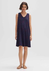 Ärmelloses dunkelblaues Kleid mit V-Ausschnitt, das ein strukturiertes Muster in Rot und Lila aufweist. Leichter Stoff, lockere Passform, mittellange Länge bis zur Mitte des Oberschenkels.