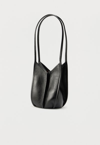 Μαύρη δερμάτινη τσάντα ώμου με μαλακή υφή, που διαθέτει δύο μακριά χερούλια και μοναδικό διπλωτό σχέδιο. Συμπαγές μέγεθος και λιτή μορφή.