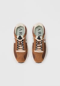 Braune Wildleder- und Mesh-Sneaker mit einem weißen Akzent und schwarzen Schnürsenkeln. Verfügt über strukturierte Paneele, eine gepolsterte Innensohle und eine abgerundete Zehenpartie.