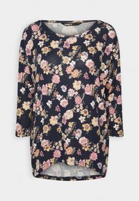 Blommönstrad topp med trekvartslånga ärmar, marinblå bakgrund och rosa, gula och vita blommor. Mjuk textur och rundad nederkant.