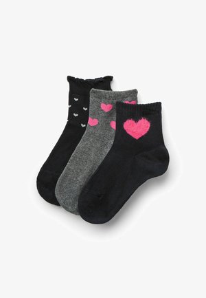 Ensemble de trois chaussettes de cheville : une noire avec de petits cœurs, une grise avec des cœurs roses, et une noire unie. Matière douce en tricot avec des bords côtes.