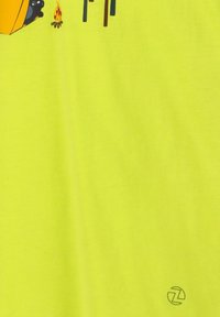 Heldergele katoenen t-shirt met kampeergrafieken: een gele tent, kampvuur en bomen, met een logo gedrukt nabij de rechteronderkant.