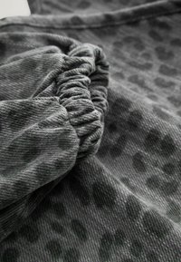 Gray fabric with a subtle leopard print texture, featuring gathered cuffs and a soft, brushed finish. Close-up view showing detail.
