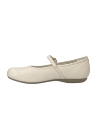 Chaussure plate en cuir beige avec un bout rond et une seule sangle ajustable sur le coup de pied. Semelle en caoutchouc basse avec motif texturé.