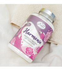 Round glass jar of bath milk with a silver lid. Label features purple and pink floral designs and text in multiple languages.