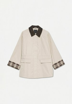 Manteau beige avec col en velours côtelé marron foncé et doublure de poignets à carreaux, équipé de poches à rabat sur le devant et de manches longues.