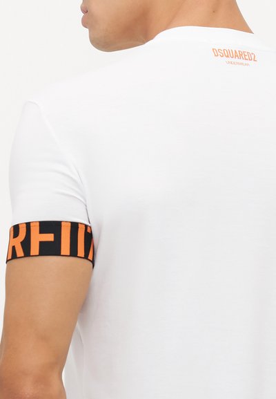White cotton t-shirt with a round neckline. Features a black band with "DSQUARED2" and orange lettering on the sleeve. Back has a small orange logo.
