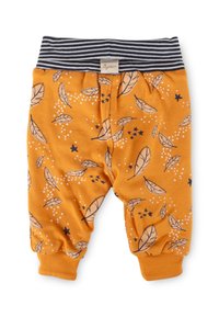 Orangene Babyhose mit elastischem, gestreiftem Bund, umgekrempelten Knöcheln sowie Feder- und Sternmustern in Schwarz und Weiß.