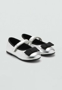 Srebrne metalik baletanke s crnom mašnom, koje imaju sigurnu trakicu i zaobljen dizajn prsta, postavljene na ravni crni đon.