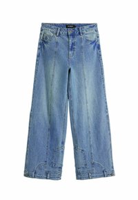 Helles blaues Jeansmodell mit weitem Bein, hoch geschnitten, mit auffälligen Nähten und patchartigen Akzenten an den Gesäßtaschen.