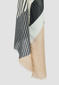 Écharpe multicolore avec des rayures noir et blanc et des accents beiges. Tissu léger avec des bords frangés et divers motifs géométriques.