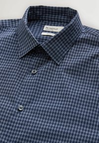 Granatowa koszula w kratę wykonana z miękkiej w dotyku tkaniny, z klasycznym kołnierzem i zapięciem na guziki przy szyi.