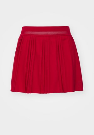 Red pleated skirt featuring a textured waistband and a solid color. Designed with a flared shape for a relaxed fit.
