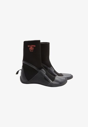 Black wetsuit boots with a neoprene upper, rubber sole, reinforced stitching, and a strap across the midfoot. Billabong logo on the front.
