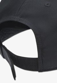 Μαύρο καπέλο με εξωτερική επιφάνεια από ομαλό ύφασμα, καμπυλωτή γείσο και ρυθμιζόμενο λουράκι με υφή στην κάτω πλευρά για καλύτερο κράτημα.