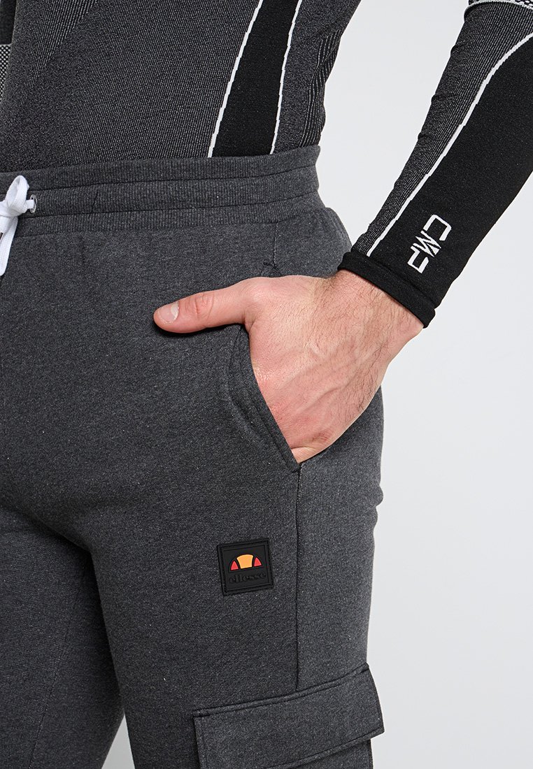 Szare dresy z elastycznym paskiem, bocznymi kieszeniami oraz kieszenią cargo, z prostokątnym logo marki w kolorowym wzorze.