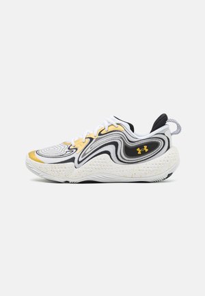 Des chaussures de sport avec un design texturé blanc, noir et or. Elles présentent des lignes fluides, une semelle rembourrée avec des taches, et un branding bien visible.