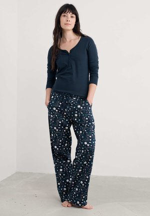 Haut à manches longues bleu marine avec un col henley associé à un pantalon de pyjama à motifs lâches avec un design céleste en blanc et vert d'eau.