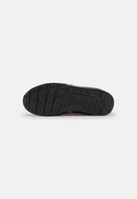 Zapato de cuero marrón con una suela de goma negra que presenta un patrón de textura en la banda de rodadura. La suela tiene una curvatura en la punta y el talón para un mejor agarre.