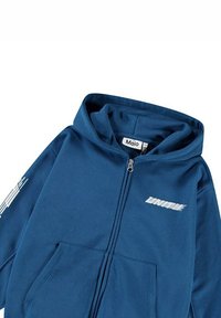 Felpa con zip di colore blu scuro con una grande tasca frontale. Presenta un logo bianco e un testo stilizzato sulla manica sinistra. Realizzata in tessuto morbido.