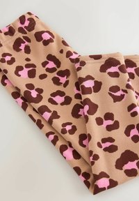 Brune leggins med pink og mørkebrun leopardprint mønster foldet på en lys overflade.