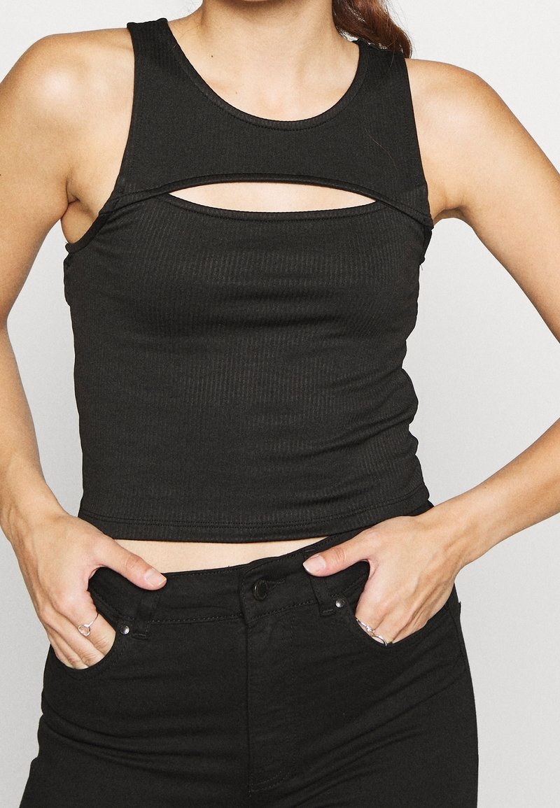 Svart ribbad crop top med rund halsringning och ett horisontellt utskärningsdetalj under bröstet, tillverkad av stretchtyg.