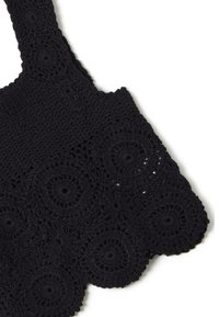 Borsa tote in crochet nera con dettagli a motivo circolare, caratterizzata da una finitura testurizzata e un bordo ondulato, ideale per un uso casual.