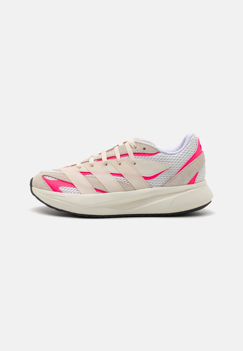 Zapatilla deportiva en color rosa y beige, hecha de malla y gamuza, con tres franjas beige, parte superior texturizada y suela de goma negra.