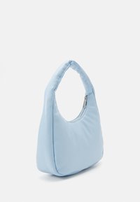 Ljust blå axelväska i mjukt tyg. Har ett böjt handtag och en dragkedjeöppning. Slät yta med en minimal design.