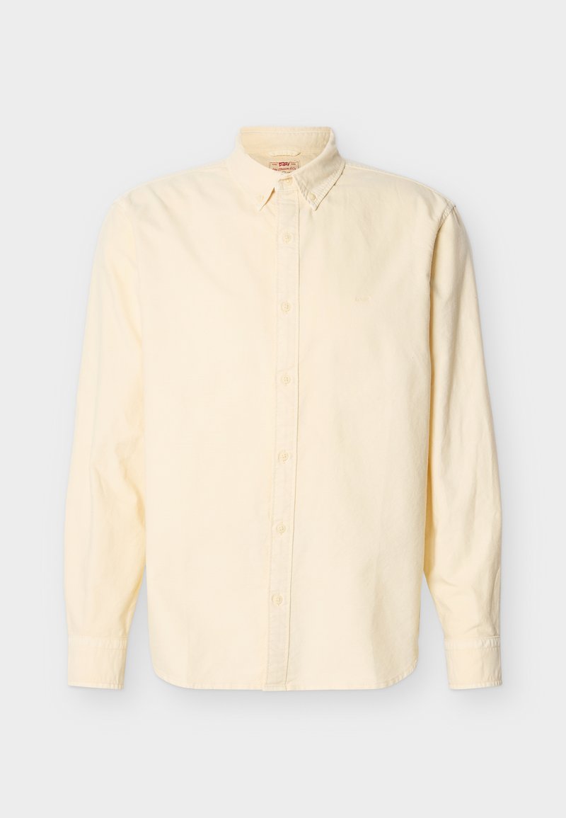 Chemise à manches longues jaune pâle avec boutons et col boutonné, logo discret sur la poitrine, sur un fond uni.