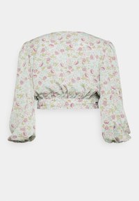 Top floral cropped em tecido verde claro e suave, com mangas bufantes e bainha franzida. Apresenta rosas cor-de-rosa e detalhes verdes por toda a peça.