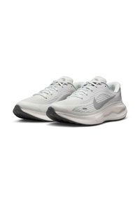 Zapatillas deportivas blancas con una parte superior de malla, diseño texturizado, acentos en gris claro y una suela acolchada. Presentan un logo de Nike en gris en el lateral.