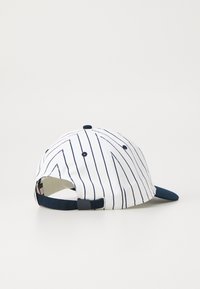 Baseball cap with a white fabric featuring vertical navy stripes. Navy visor and adjustable strap at the back with a small button.
