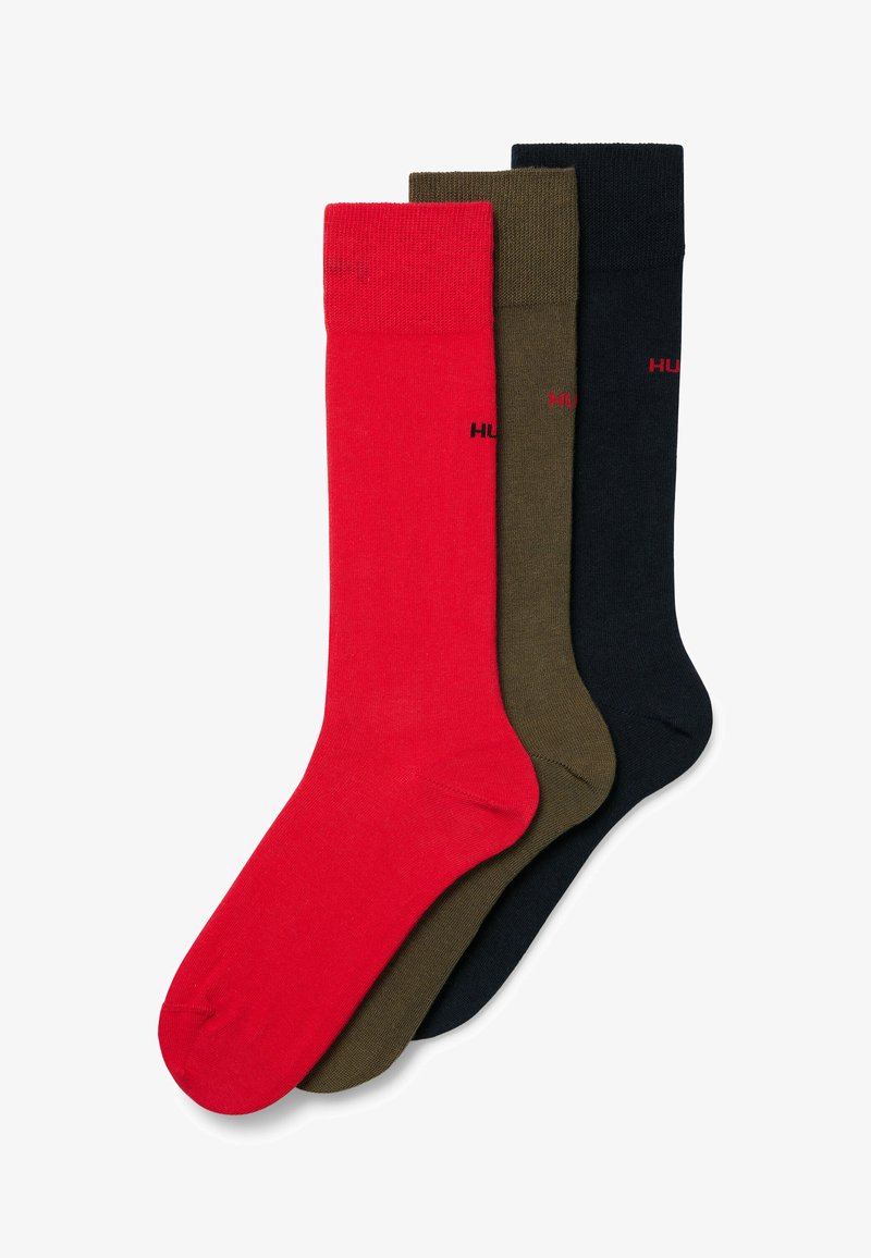 Três pares de meias de algodão em vermelho, verde-oliva e preto. Cada par apresenta um punho canelado e um pequeno detalhe com o logo na lateral.