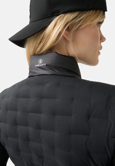 Sort puffer-vest med quiltet tekstur, høj krave og logoet "FIRE+ICE" i hvid. Stoffet ser let og glat ud.