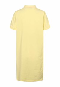 Pols kleita mīkstā dzeltenā kokvilnā ar īsām piedurknēm, klasisku apkakli un taisnu piegriezumu. Vienkāršs dizains, bez rotājumiem vai rakstiem.