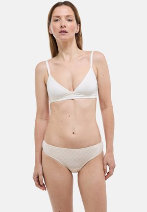 Soutien-gorge sans couture blanc à fines bretelles, associé à une culotte beige avec un motif texturé subtil. Design simple et près du corps.