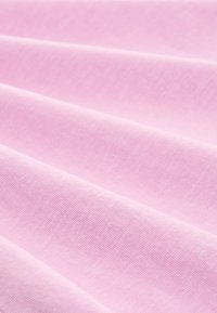 Soft pink cotton fabric with a smooth texture, featuring subtle folds and a uniform surface pattern, ideal for apparel or textile projects.