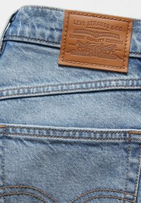 Blauwe spijkerbroek met een leren label waarop "Levi Strauss & Co." staat. Gedetailleerde stiksels en een klassiek zakontwerp.