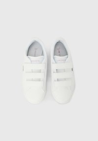 Λευκά αθλητικά παπούτσια με τρεις λουριά από βέλκρο, ύφασμα επάνω μέρος, επενδυμένο κολάρο και ένα μικρό λογότυπο στο πλάι. Μαλακή εσωτερική επένδυση.